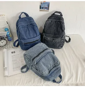 Dettaglio dei tre zaini in denim lavato retrò nei colori blu scuro, blu chiaro e grigio nero