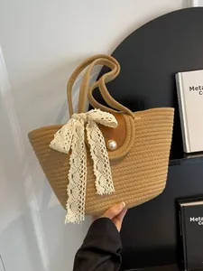 Sac cabas tressé marron avec nœud en dentelle blanche et bouton perle vu de face