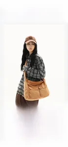 Detailed view of caramel canvas messenger bag with large front cargo pockets on model