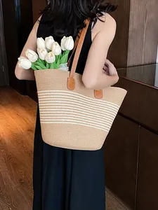 Large straw tote bag with white stripes and brown leather straps for beach holidays