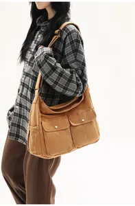 Close-up of retro brown canvas messenger bag featuring large utility flap pockets