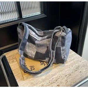 Detailed top view of a patchwork denim crossbody bag with zipper and adjustable strap