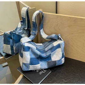 Detail of multi-tone denim patchwork shoulder bag with adjustable silver buckle strap