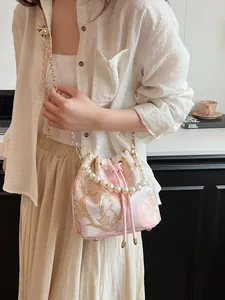 Elegant pink silk bucket bag with floral embroidery and luxury pearl handle