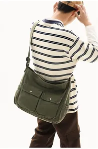 Army green canvas messenger bag featuring front pockets and adjustable wide strap