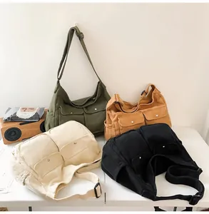 Detail of four canvas messenger bags in green, yellow, beige and black with front pockets