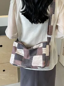 Retro patchwork washed denim crossbody bag with wide strap worn by a model