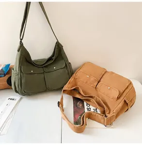 Detail view of khaki and army green canvas messenger bags with flap pockets and metal buttons