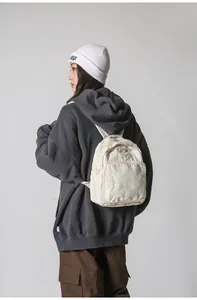 Vista lateral detallada de una mini mochila de lona crema con estilo casual callejero