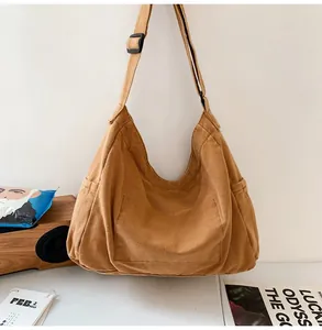 Detail view of large camel canvas messenger bag with adjustable strap and side pocket