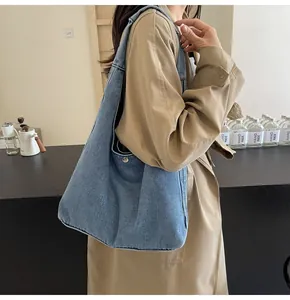 Détail du grand sac porté épaule en jean avec sangle large et fermeture à pression