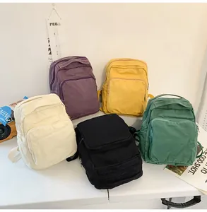 Detalle de mochilas de lona lavada en colores morado, amarillo, crema, negro y verde
