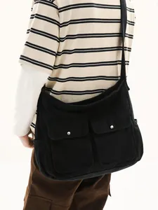 Black canvas messenger bag with dual front pockets shown on model for casual wear