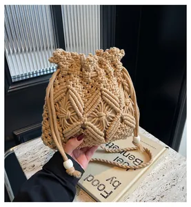 Detail van beige handgeweven emmertas met gehaakte patronen en decoratieve kralen