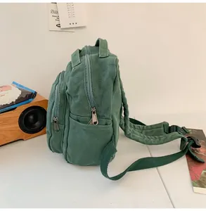 Vista lateral de la mochila de lona verde retro con bolsillos y correas acolchadas