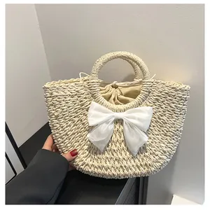 Vue détaillée du sac en paille avec grand nœud en organza blanc et doublure à cordon