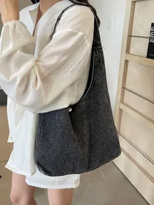 Sac hobo minimaliste en denim anthracite avec un fermoir à bouton métallique