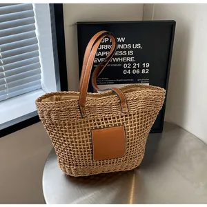 Détail d'un sac cabas en paille tressée avec poignées en cuir PU marron et doublure
