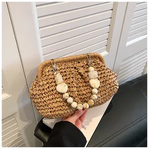 Detail of woven straw bag featuring marble textured beaded handle and metal clasp