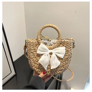 Détail du sac en paille tressée avec nœud blanc et doublure à pois à cordon de serrage