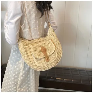 Detail view of woven straw hobo bag with brown PU leather flap and metal hardware
