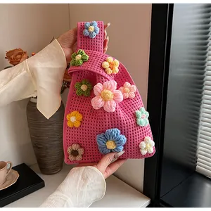 Detalle de bolso saco de punto rosa con flores de ganchillo 3D y textura suave