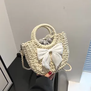 Détail du sac à main en paille beige avec nœud blanc et doublure à pois à cordon