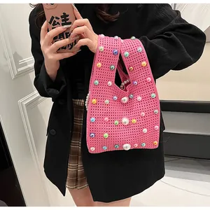 Detailaufnahme der rosa Stricktasche mit bunten Perlen und Häkelmuster-Textur