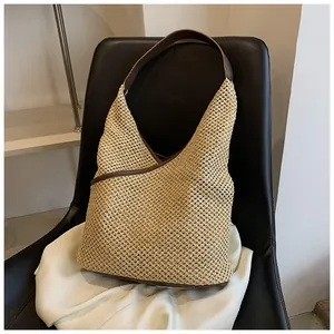 Dettaglio della trama della borsa in paglia intrecciata con manici in pelle marrone