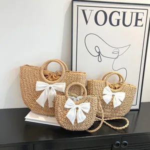 Ensemble détaillé de trois sacs en paille tressée avec grands nœuds blancs de plage