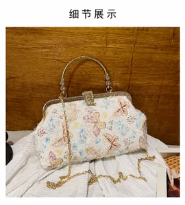 Detailansicht von Schmetterlingsmuster und Goldgriff an einer Retro-Handtasche