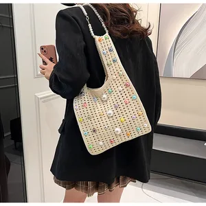 Detailansicht der beigen Stricktasche mit bunten Perlen und Perlen-Schultergurt