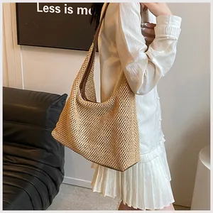Primo piano della borsa a spalla in paglia intrecciata con finiture in pelle marrone scuro