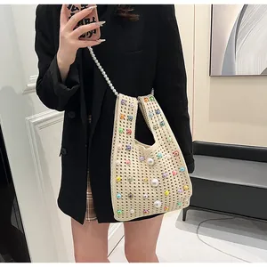 Detaillierte Strickstruktur und bunte Perlenverzierung auf beige Häkeltasche