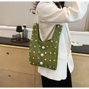 Detail einer grünen Häkeltasche mit bunten Perlen und großem Perlen-Schultergurt