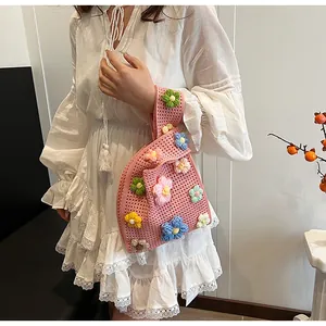 Detalle del tejido de punto de un bolso de ganchillo rosa con flores en 3D