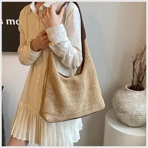 Dettaglio della borsa hobo in paglia intrecciata con finiture e tracolla in pelle marrone