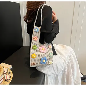 Detalle del bolso de ganchillo hecho a mano con flores 3D y correa de perlas blancas