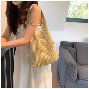 Vista dettagliata della borsa a spalla in maglia traforata con trama intrecciata e stile