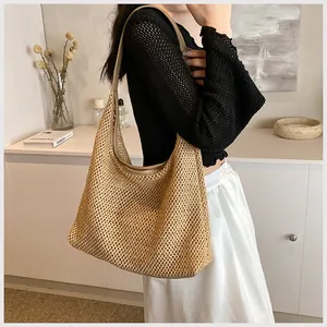 Dettaglio borsa a spalla in paglia intrecciata con tracolla in pelle per le vacanze