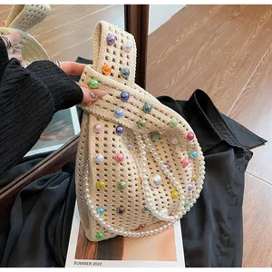 Detail der beigen Häkeltasche mit bunten Perlen und großem weißen Perlen-Tragegriff