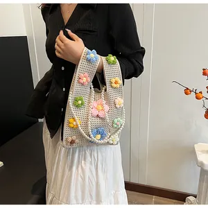 Detalle del bolso de punto hecho a mano con asa de perlas sintéticas y flores 3D coloridas