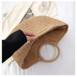 Détail du sac en paille tressée avec doublure en tissu marron et poignée ronde chic