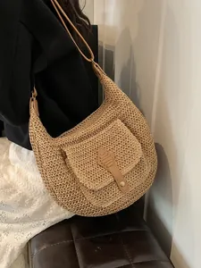 Bohemian woven straw hobo bag with brown leather straps and front pocket for beach vacation