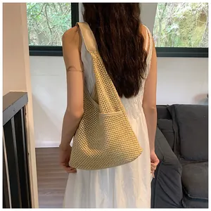 Vista posteriore di una borsa tote intrecciata in corda di cotone beige con trama