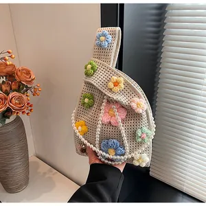 Detalle de bolso de ganchillo hecho a mano con flores 3D de colores y cadena de perlas