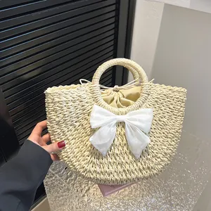 Détail du sac en paille avec nœud en mousseline blanche et doublure intérieure