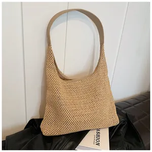 Dettaglio della borsa a spalla in paglia intrecciata con finiture in pelle e rete
