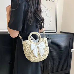 Détail du sac de plage en paille tissée avec grand nœud en soie et doublure à pois