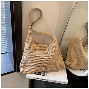Dettaglio della borsa in paglia intrecciata con tracolla in pelle e trama fine
